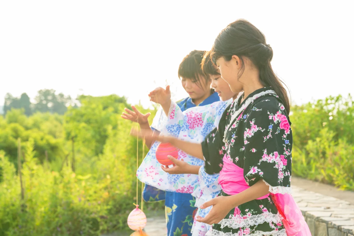 河原で浴衣を着る小学生