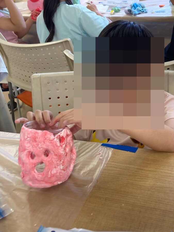 色ねん土でつくった小物入れを仕上げる小学生